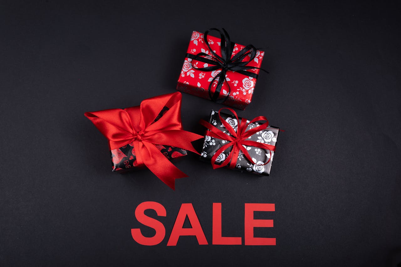 Stylish gift boxes with red ribbons on sale. Perfect for promotions and festive occasions.